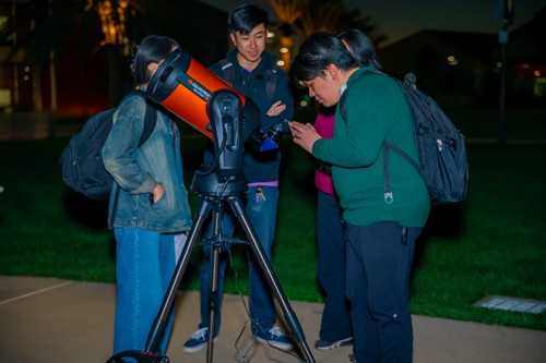 Students looking into the sky with telescopes