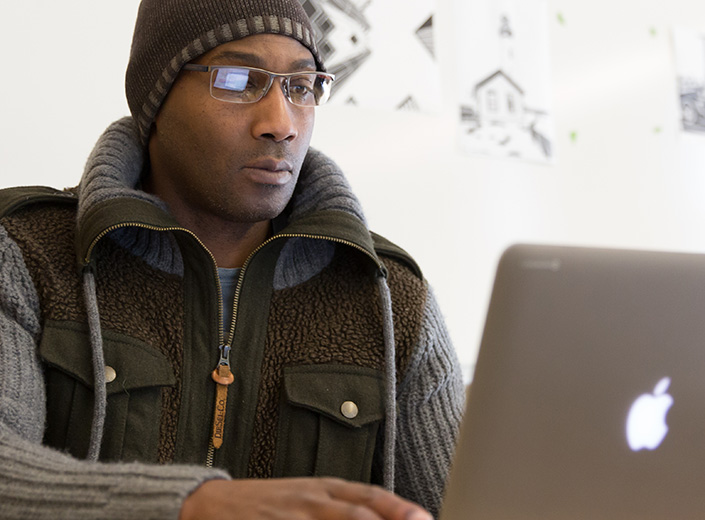 A man is pictured working at a laptop.