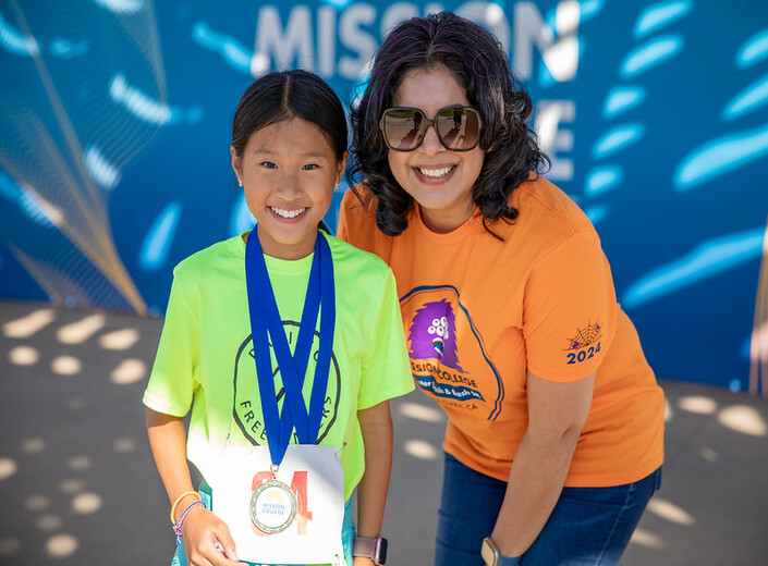 Dr. Awan with young girl receiving her medal.