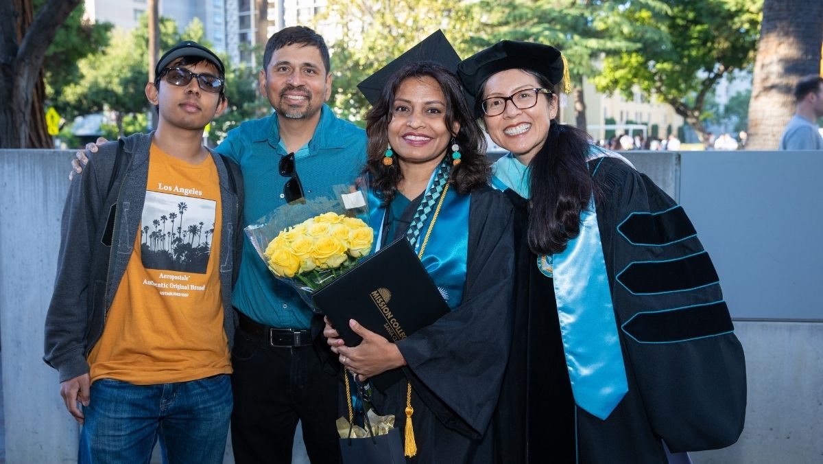 Mission College graduate smiling with diploma