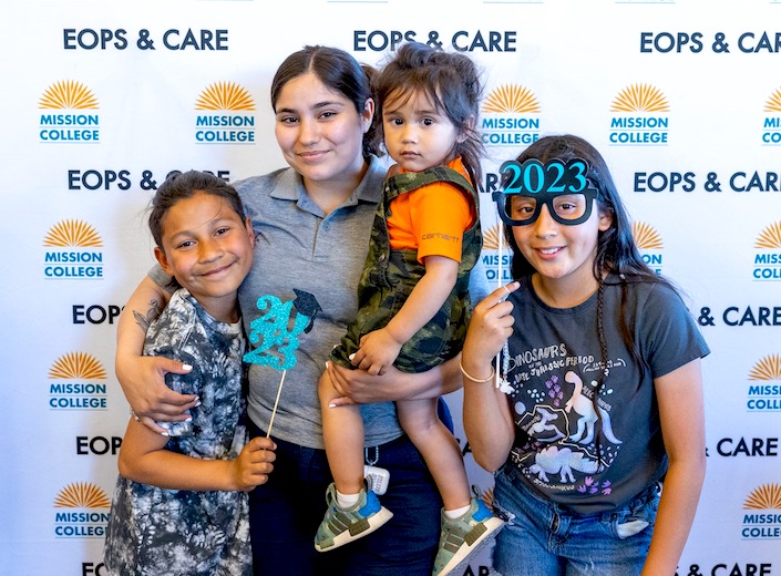 EOPS/Care family stands in front of branded backdrop at event.