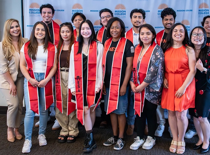 Group of MESA students with red/orange sashes.